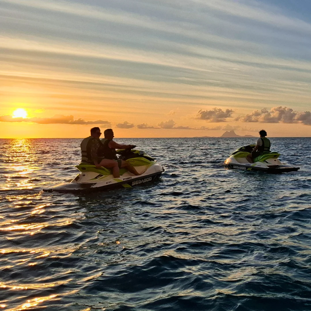 Randonnée en jet ski au coucher du soleil sur le lagon de Raiatea, vue sur l'horizon doré. Coucher de soleil