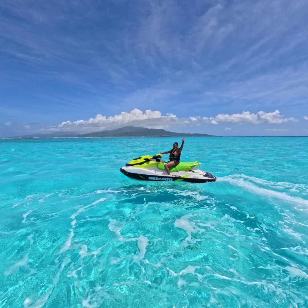 Femme pilotant un jet ski Sea-Doo dans les eaux turquoise du lagon de Raiatea, Polynésie française. Femme seule sur jet ski